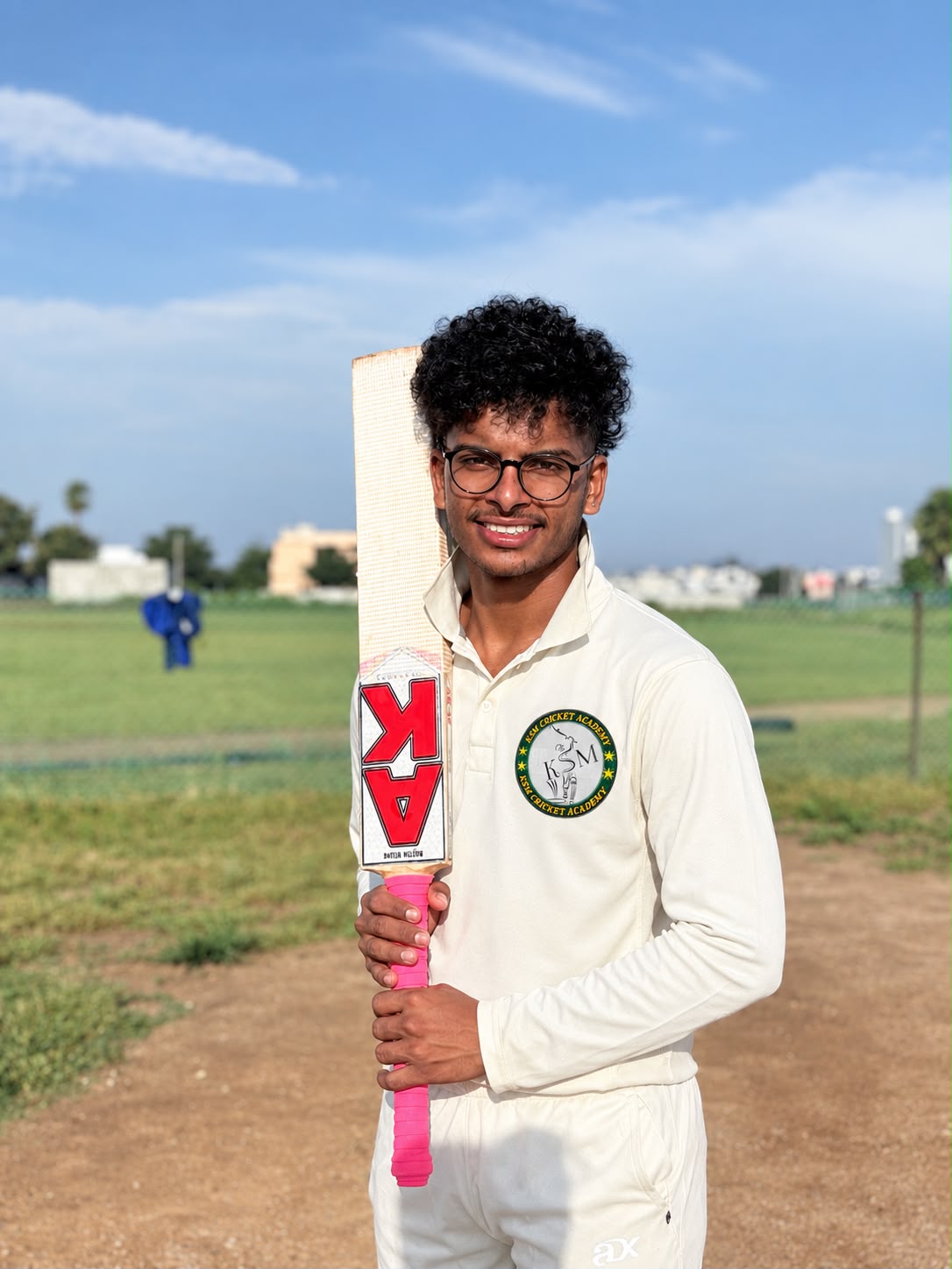 KSM academy batter holding a cricket bat on the ground